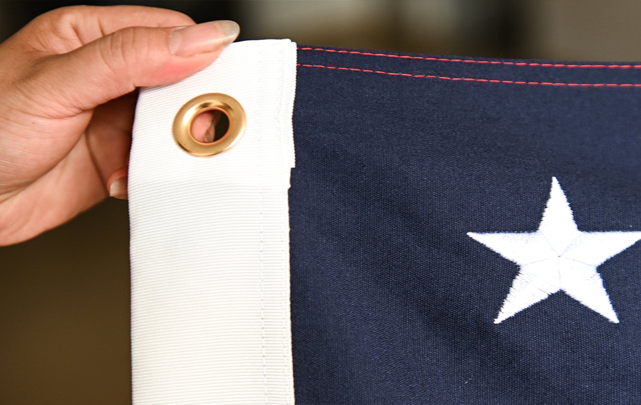 FlagsWin technicians inspecting a batch of 420D polyester national flags on an automated quality-control line with Pantone color charts