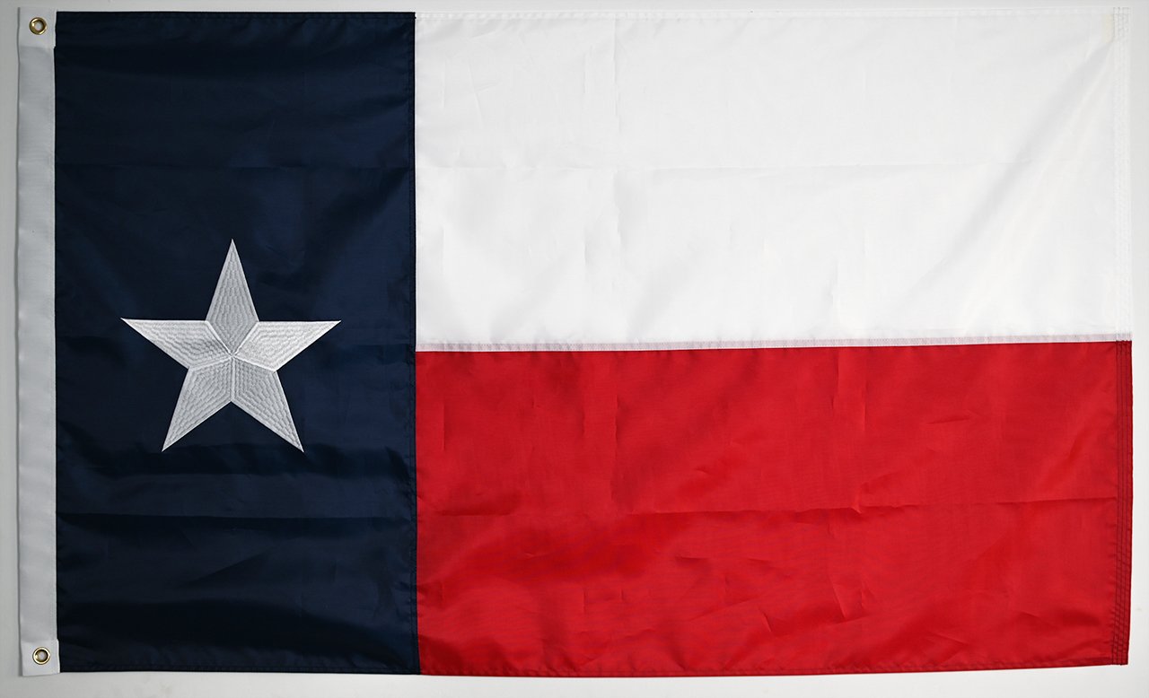 Side-by-side comparison of a 210D nylon flag and a 420D heavy-duty polyester flag, focusing on the stitched hems and brass grommets.