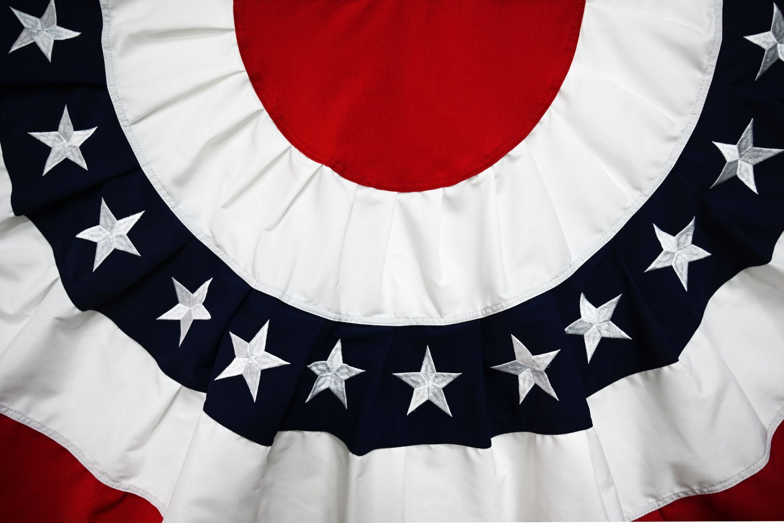 close-up of flag fabric hem with double stitching, brass grommets and reinforced fly end on a flagpole
